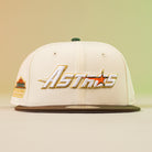 A pink Oompa Box Houston Astros 5950 Fitted New Era Hat featuring gold and white Astros embroidery on the front, a brown brim, and a commemorative patch on the left side.