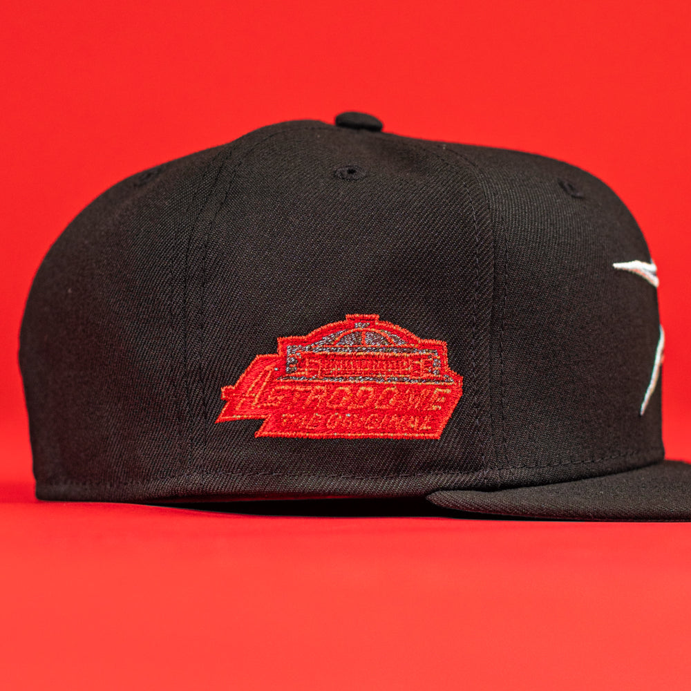 The Shootah Black Silver New Era Hat 5950 Fitted features a red and white embroidered patch with text and a building outline on the front, all against a solid red background.