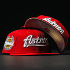 Two Sunnyside Bo Bundy WS05 Houston Astros New Era 5950 fitted hats in red with white embroidered logos. One displays the Astros text and side patch; the other is upside down, showing the underside of the brim.