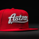 The Sunnyside Bo Bundy WS05 Houston Astros New Era 5950 Fitted Hat features "Astros" in white script on a red cap, displayed against a black background.