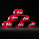 Six red Sunnyside Bo Bundy WS05 Houston Astros New Era 5950 Fitted hats with white Astros lettering are arranged in a pyramid on a black background. Some feature a gold and white commemorative side patch.