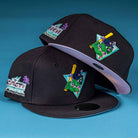 Two black Flamingo and Chill Bo Bundy 2022 Houston Astros New Era 5950 Fitted caps with colorful embroidery of a lizard swinging a bat, palm trees, and "The Palm Beaches" text on the side against a blue background.