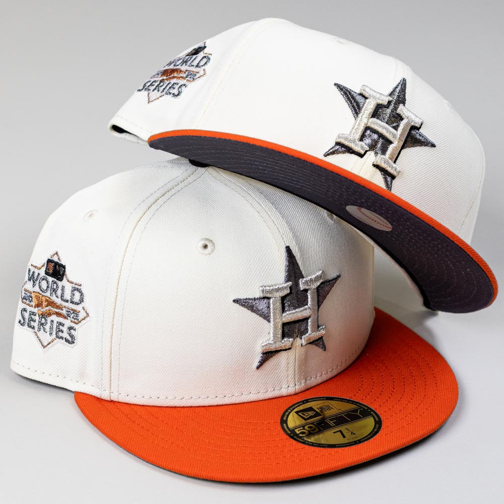 Two Orange Soda New Era WS22 Houston Astros 5950 Fitted hats, featuring large H star logos and World Series patches, are stacked—one flat, the other on top.