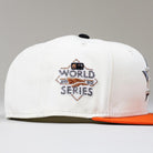 The Orange Soda New Era WS22 Houston Astros 5950 Fitted Hat features a white crown, orange brim, and embroidered World Series logo on the side. The background is plain light gray.