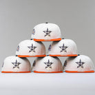 Six Orange Soda New Era WS22 Houston Astros 5950 Fitted hats are stacked in a pyramid against a plain, light gray background.