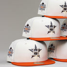A stack of Orange Soda New Era WS22 Houston Astros 5950 Fitted hats, each with orange brims, the Astros star logo on the front, and a World Series patch on the side, displayed against a plain background.