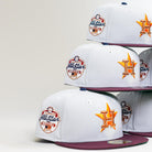 Four Shibuya Lights New Era Silver Japan Houston Astros 5950 Fitted hats are stacked, each with a purple brim, orange Astros logo, and an MLB All-Star Series patch. The background is plain and light-colored.