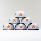 Six Shibuya Lights New Era Silver Japan Houston Astros 5950 Fitted hats are arranged in a pyramid on a white background, showcasing the Astros logo on the front and a commemorative patch on the side.