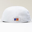 A close-up of the back of a white Shibuya Lights New Era Silver Japan Houston Astros 5950 Fitted cap showcases a small, embroidered MLB logo in blue, white, and red above the brim against a plain light background.