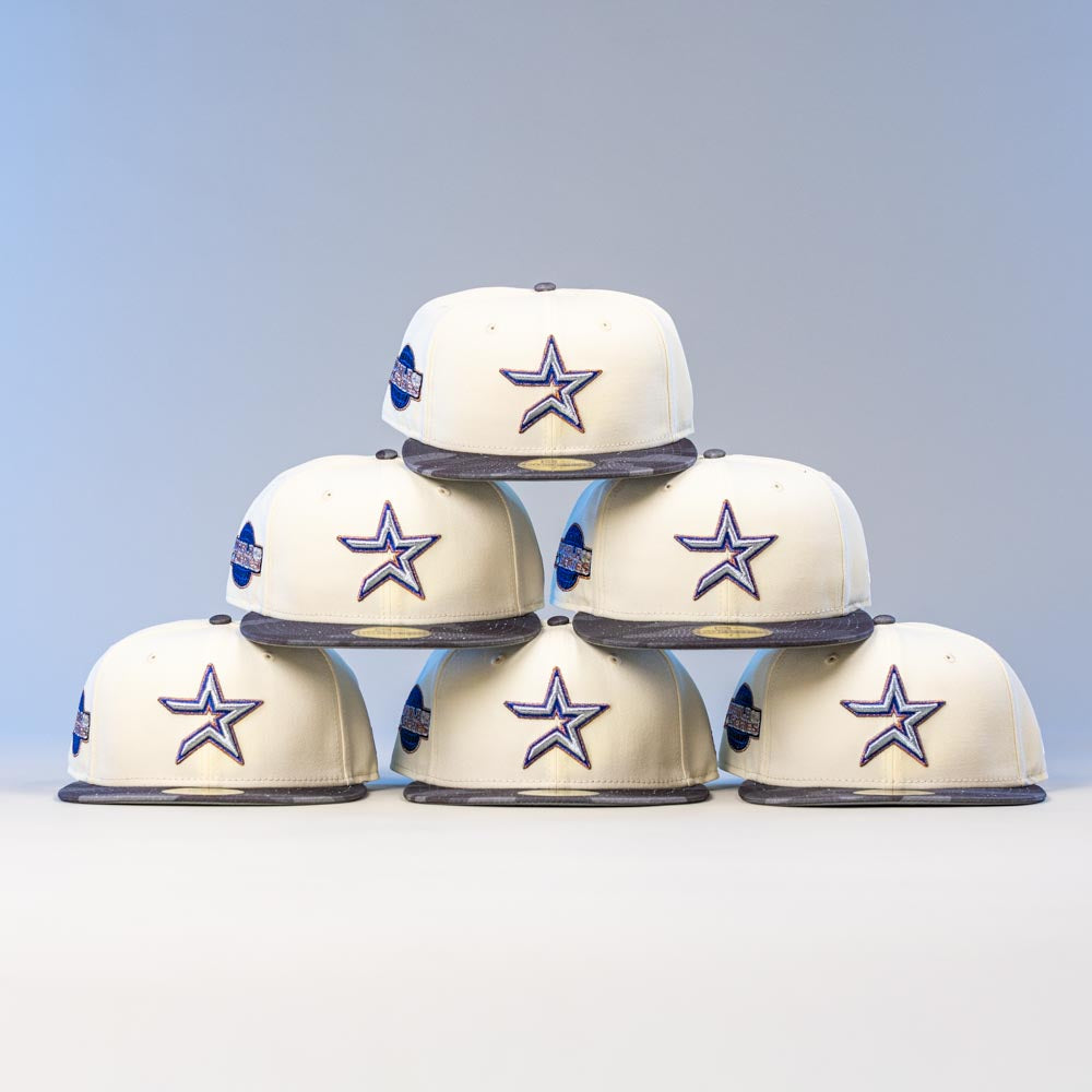 Six Dark:30 New Era Chrome Black Camo Houston Astros 5950 Fitted hats are stacked in a pyramid against a plain background. The cream-colored caps feature blue star logos, gray brims, and a side patch.