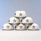 Six Dark:30 New Era Chrome Black Camo Houston Astros 5950 Fitted hats are stacked in a pyramid against a plain background. The cream-colored caps feature blue star logos, gray brims, and a side patch.