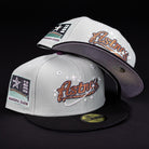 Two Pixie Dust New 2000 Houston Astros New Era Hat 5950 Fitted caps, in gray and black with the Astros logo and a 2000 inaugural season patch, are displayed against a black background.