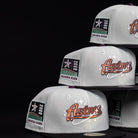 A stack of Pixie Dust New 2000 Houston Astros New Era Hat 5950 Fitted hats is displayed against a black background, featuring the team logo on the front and a "2000 Inaugural Season" patch on the side.