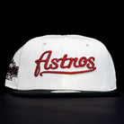 The Red Soda New Era HOF Red Black Chrome Houston Astros 5950 Fitted Hat features "Astros" in red script on the front, with a black brim, shown against a black background.