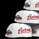 A stack of Red Soda New Era HOF Red Black Chrome Houston Astros 5950 Fitted hats, each featuring a red embroidered Astros logo and a Houston All-Star Game patch, set against a black background.