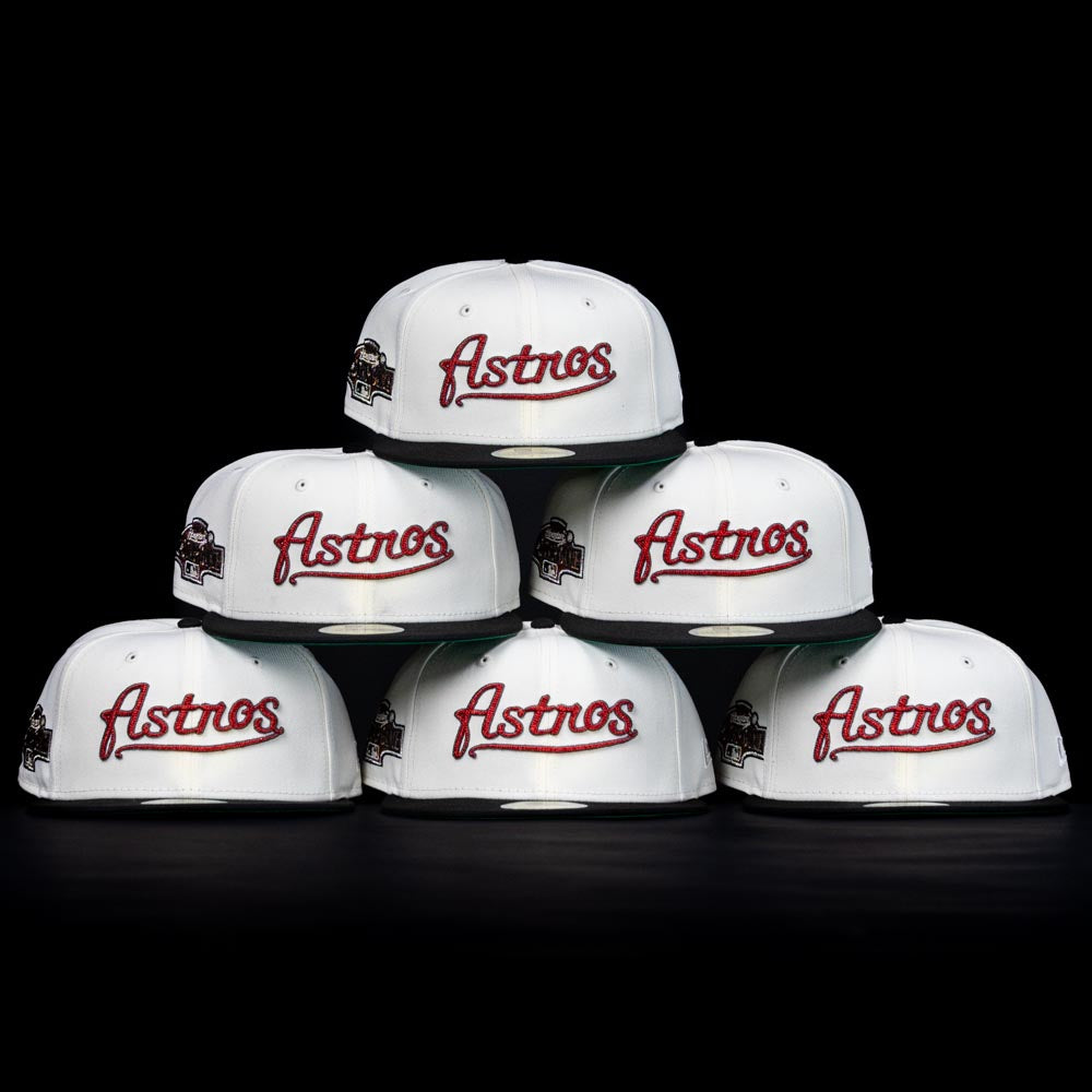 Six Red Soda New Era HOF Red Black Chrome Houston Astros 5950 Fitted Hats are stacked pyramid-style on a black background. Each fitted cap features an Astros logo and a side patch, celebrating the team’s history.