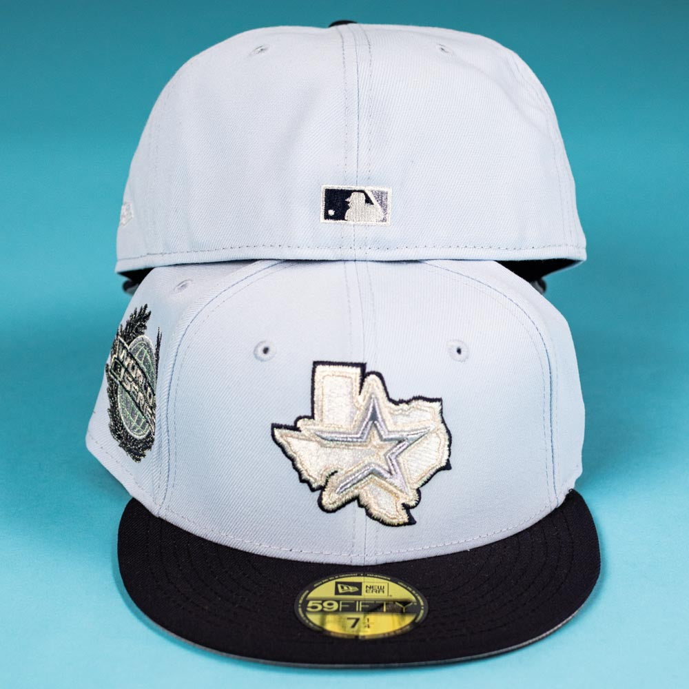 Two light blue Hard Freeze WS05 Houston Astros New Era 59FIFTY Fitted hats are stacked; the bottom features a Texas outline and star logo, black brim, and sticker, while the top displays the back with a small MLB logo.