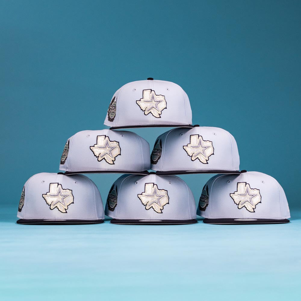 Six Hard Freeze WS05 Houston Astros New Era Hat 5950 Fitted caps are stacked in a pyramid against a blue backdrop, each featuring an embroidered Texas outline, ideal for Astros fans.