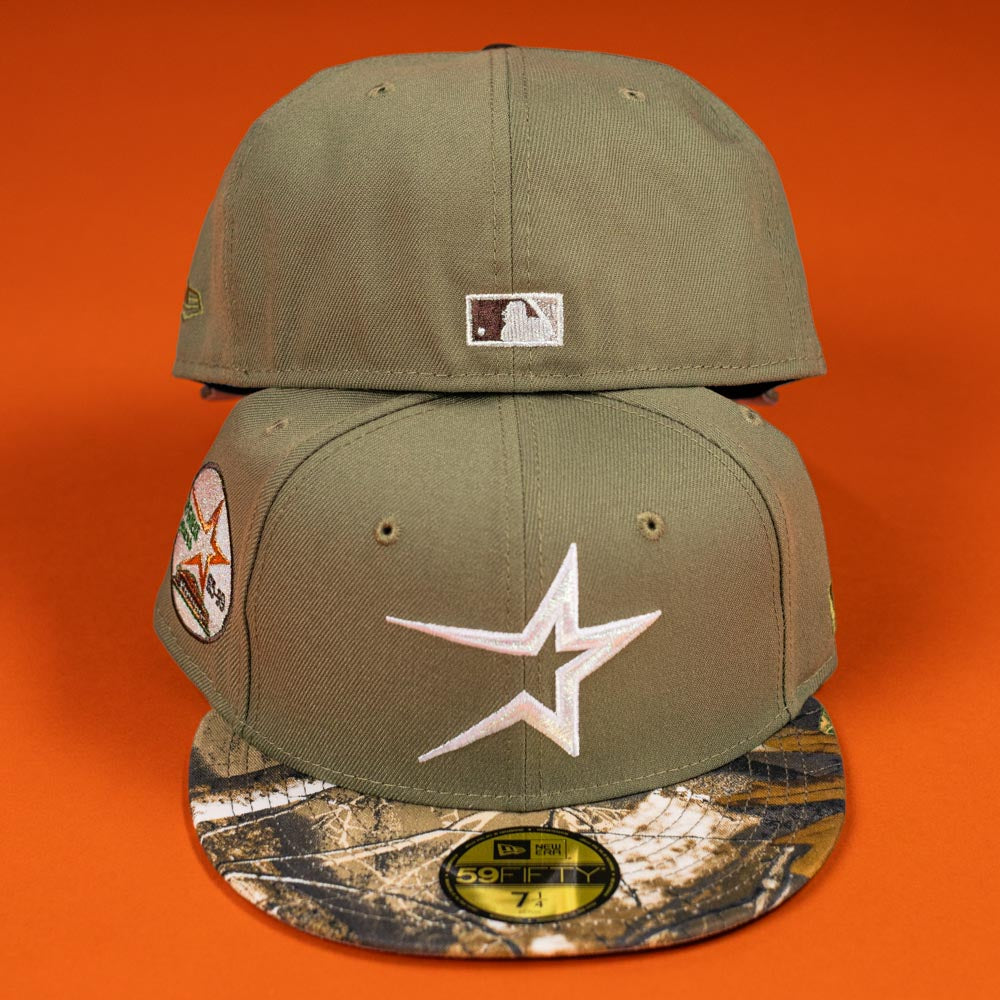 Two Pre-Order Wall Hanger New Era Bark Real Tree Houston Astros 5950 Fitted hats—olive green with camo brims and white star logo, one front, one back—displayed on orange. Pre-order now for in-store pick-up or flexible shipping.