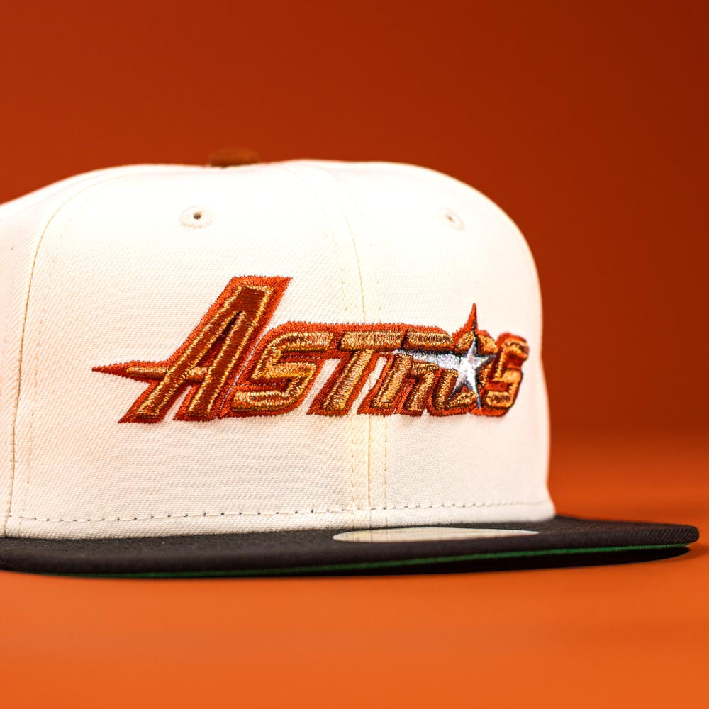 The Rustic Sunset Houston Astros New Era Hat 5950 Fitted features a white and black design with an embroidered orange and gold Astros logo with a star on an orange background.
