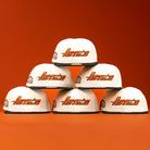 Six Rustic Sunset Houston Astros New Era Hat 5950 Fitted caps are arranged in a pyramid, each displaying an orange logo against a vibrant orange background.