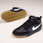 The DX4361005 Black Gum Leo Baker React Nike SB Suede Leather Skateboarding Shoes feature white swooshes, gum rubber soles, and a durable herringbone tread—ideal for skateboarding. One shoe is upright; the other reveals the grippy sole.