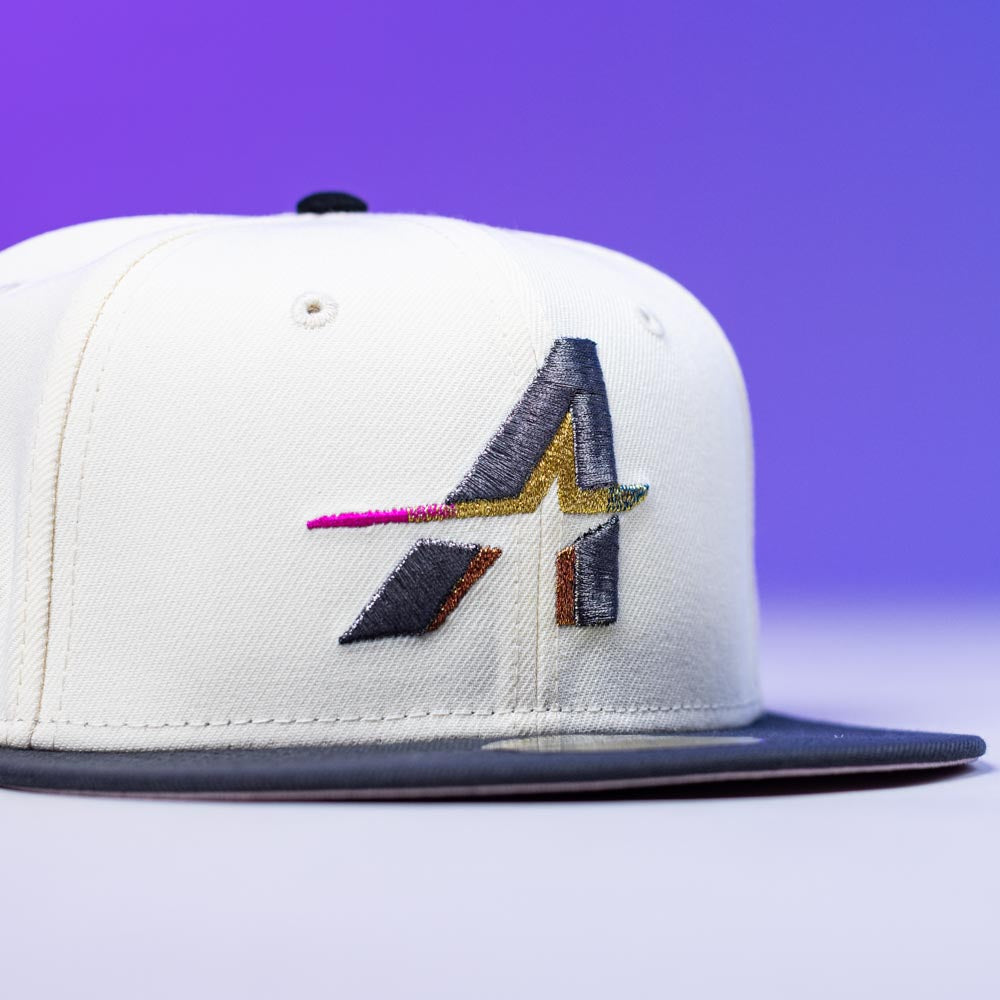 The Trilltiberi Rushmore WS22 Chrome Graphite Houston Astros New Era Hat 5950 Fitted is a white cap with a black brim, featuring an embroidered multicolored stylized A and star Astros logo on the front against a purple gradient background.