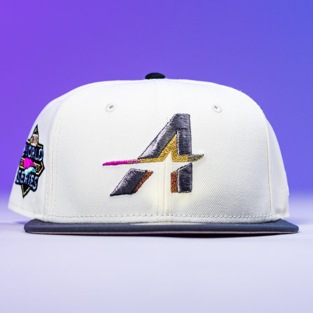 A Trilltiberi Rushmore WS22 Chrome Graphite Houston Astros New Era Hat 5950 Fitted with a white crown, gray brim, stylized gold/black/pink A logo on the front, and a 2001 World Series patch on the side, set against a purple gradient background.