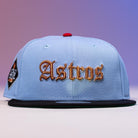 The Sicko Mode Rushmore 2017 B Blue Black Houston Astros New Era 5950 Fitted Hat features a light blue crown, black brim, gold Old English Astros front embroidery, and a left patch on a purple-to-pink gradient background.