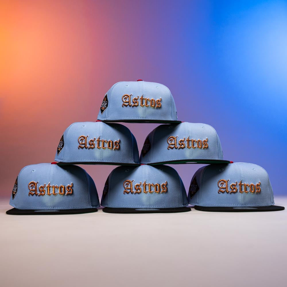 Six Sicko Mode Rushmore 2017 B Blue Black Houston Astros New Era 5950 Fitted hats are stacked in a pyramid, highlighted with bold orange lettering and set against a gradient of orange and blue light.