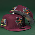 Two Pinkerton 2.0 Rushmore 2000 Maroon Houston Astros New Era Hat 5950 Fitted caps with Texas-shaped star patches and “Inaugural Season 2000” embroidery are displayed against a dark green background.