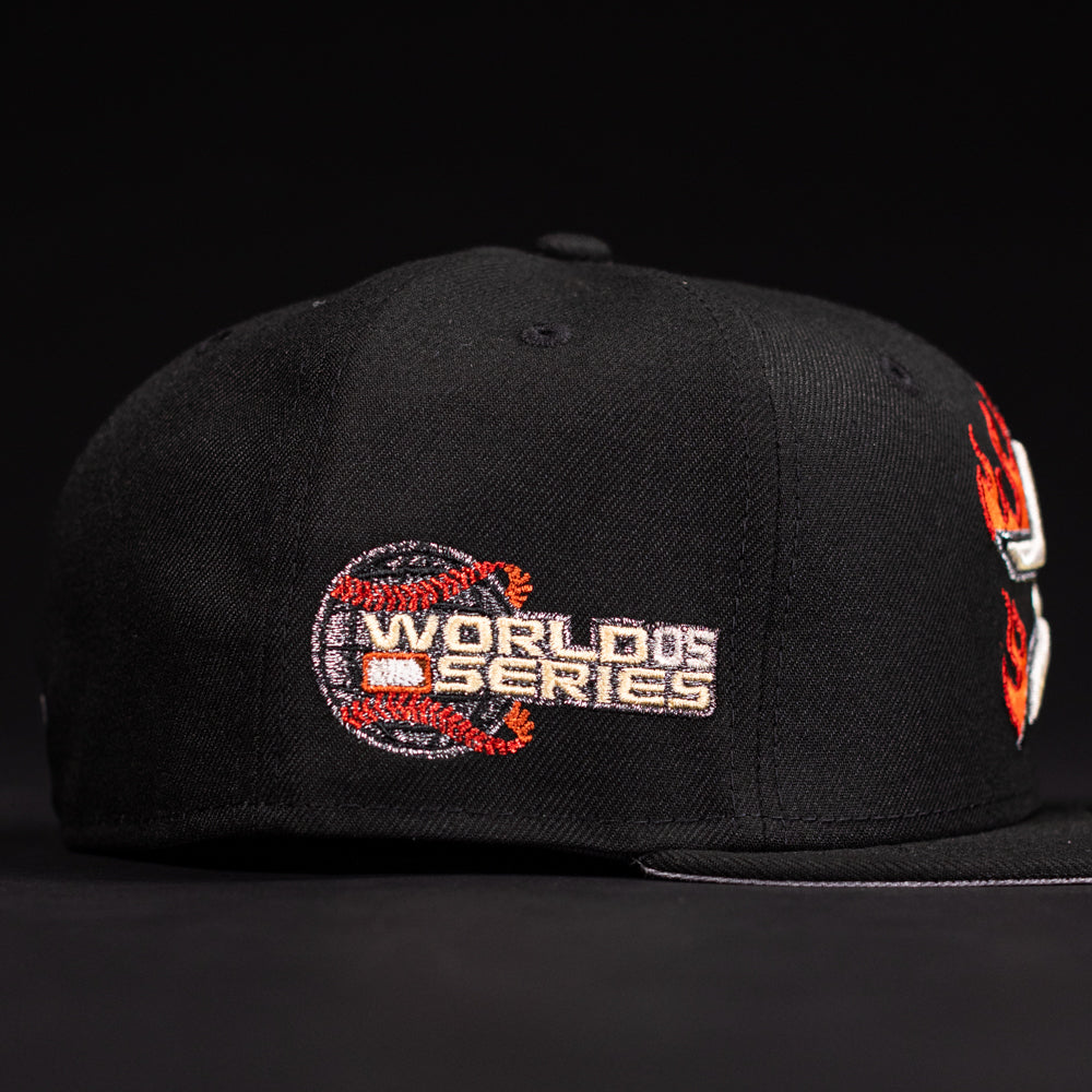 The La Flame Rushmore WS05 Fire Black Houston Astros New Era 5950 Fitted Hat features a black design with an embroidered World Series logo and a red dragon wrapped around a baseball on the side.