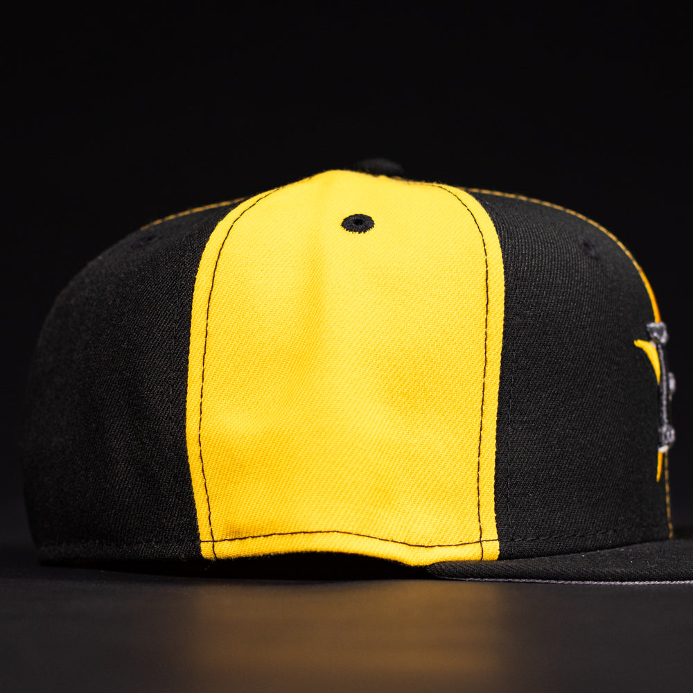 The Hazmat Rushmore Gold Black Pinwheel Houston Astros New Era Hat 5950 Fitted features bold gold and black panels with striking details, presented against a dark background.