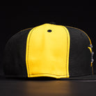 The Hazmat Rushmore Gold Black Pinwheel Houston Astros New Era Hat 5950 Fitted features bold gold and black panels with striking details, presented against a dark background.