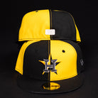 Two Hazmat Rushmore Gold Black Pinwheel Houston Astros New Era 5950 Fitted hats are shown; the front displays the Astros H star logo, while the back reveals a rectangular patch. Both caps are set against a black background.
