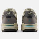 Rear view of the 933 GRY Andrew Reynolds Gray Day New Balance Numeric suede skateboarding shoes in gray with beige and blue accents, heritage details, “NB” heel logos, and chunky off-white soles.