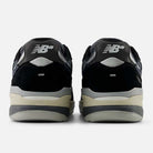 A pair of Black Eclipse 933 BNT Andrew Reynolds New Balance Numeric suede skateboarding shoes seen from the back, with a silver NB logo on black and gray heels, light gray soles, a beige midsole, and classic heritage design influences.