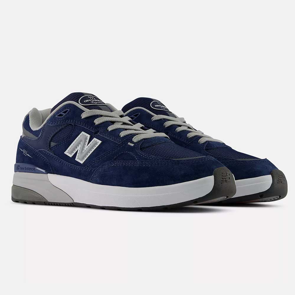 A pair of 933 LNV Navy Slate Gray Andrew Reynolds New Balance Numeric Suede Skateboarding Shoes featuring navy blue suede uppers, white midsoles, grey outsoles, and grey laces. Highlighted by the signature white "N" logo on the sides, these sneakers combine a heritage-inspired design with premium cushioning for all-day comfort, displayed against a plain white background.