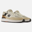 A pair of 933 ONE Quicksand Sea Salt Gray Andrew Reynolds New Balance Numeric suede skateboarding shoes featuring beige and tan hues with black and white accents, mesh panels, a chunky white sole, and premium cushioning inspired by heritage design.
