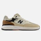 A beige and tan 933 ONE Quicksand Sea Salt Gray Andrew Reynolds New Balance Numeric Suede Skateboarding Shoe, accented with black and white details and featuring the iconic N logo on the side along with "933" text near the heel, highlights its heritage skate-inspired design against a white background.
