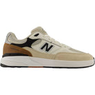 Introducing the 933 ONE Quicksand Sea Salt Gray Andrew Reynolds New Balance Numeric Suede Skateboarding Shoes—a beige and tan sneaker with black and brown accents, boasting a white and black sole, ABZORB midsole for exceptional cushioning, and the signature ‘N’ on the side—delivering comfort and style inspired by Andrew Reynolds’ legendary skate shoes.