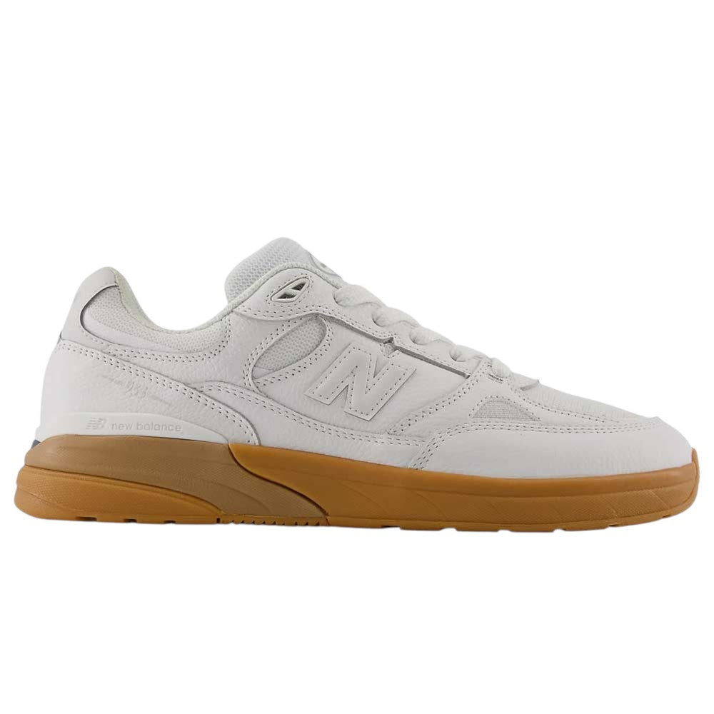 A side profile view displays the 933 WWB White Black Andrew Reynolds New Balance Numeric Suede Skateboarding Shoe, featuring a white upper with a gum sole and an ABZORB midsole for enhanced cushioning, set against a plain white background.