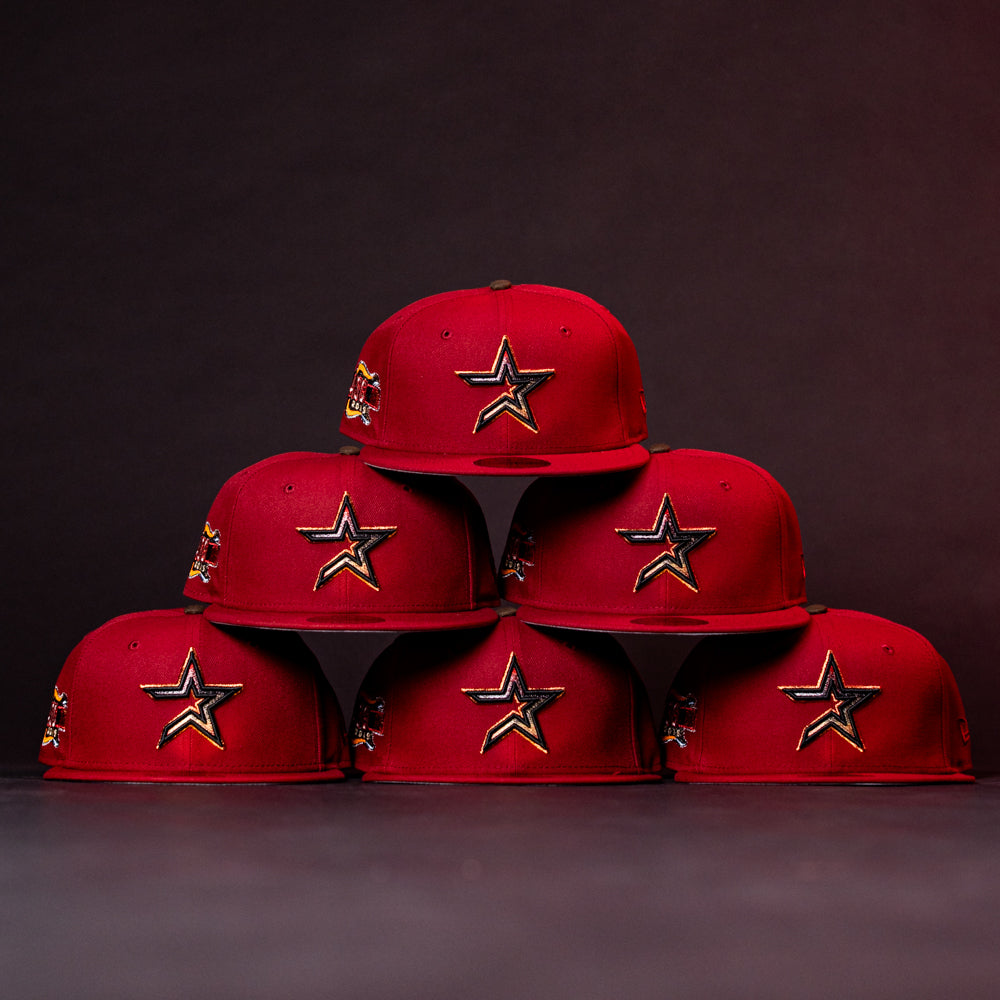 Six ASG19 Bred Houston Astros New Era Hat 5950 Fitted caps are stacked in a pyramid against a dark background, each featuring the team’s gold and black star logo on the front.