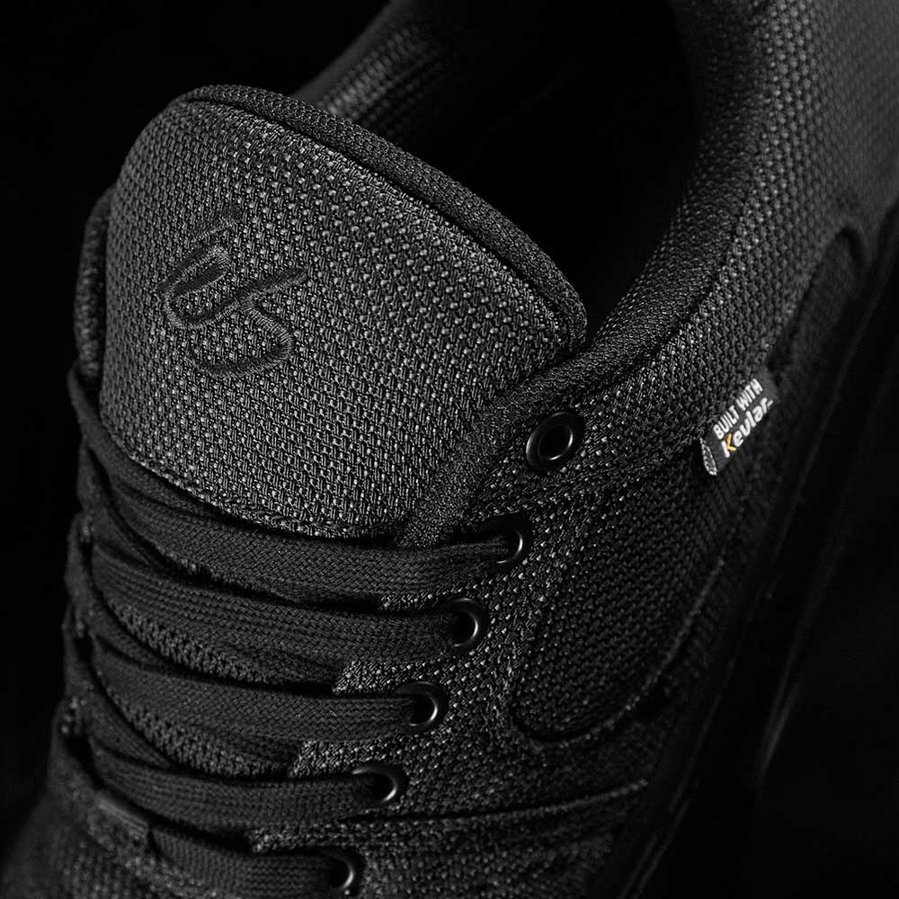 Close-up of Accel Kevlar Black Es Shoes Skateboarding, featuring a black textured finish, embroidered logo on the tongue, black laces and eyelets, plus a woven SUMMIT EU CAL 42 tag—ideal for skateboarding style.