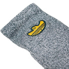 A close-up of the gray knit Gonz Art Sock KD3674 by Adidas Skateboarding, featuring a yellow and black embroidered sombrero.