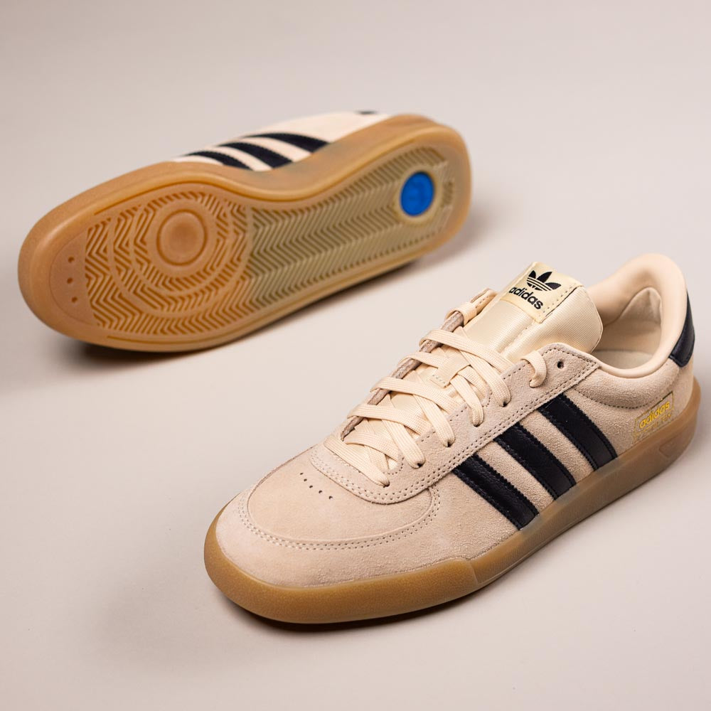 A pair of HP3510 Tan Black Glenburn Adidas Skateboarding Suede Shoes—one on its side revealing the gum sole, the other upright showing black stripes, gold CAMPUS text, and the Adidas logo.