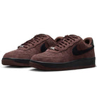 A pair of Air Force 1 Black Light Chocolate HM8517201 Nike SB suede skateboarding shoes featuring a brown upper with black swooshes, black soles, matching brown laces, and signature Nike Air cushioning, displayed on a white background.