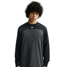 A person wears the Airmail Longsleeve IM5430060 Black Gray Skate Longsleeve T-Shirt, a durable, midweight cotton long-sleeve crewneck in black and gray featuring a small logo patch at the center of the neckline.
