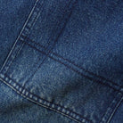 Close-up of Aleka Dark Indigo Denim Jeans by Butter Goods, showcasing blue cotton denim fabric, visible stitching, sturdy seams, and the textured weave that reflects their signature loose fit and durable construction.