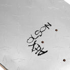 A close-up of the Alex Olson Silver Metal Deck 8.5 by Violet Skateboards, featuring a diamond plate graphic and "ALEX OLSON" printed in rough black letters near the mounting holes.